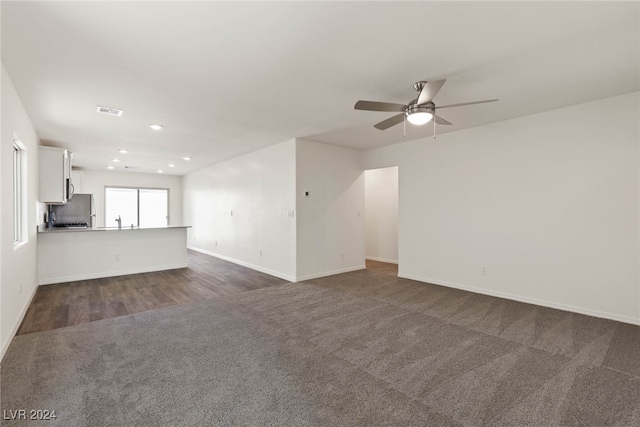 unfurnished living room with dark wood-type flooring and ceiling fan