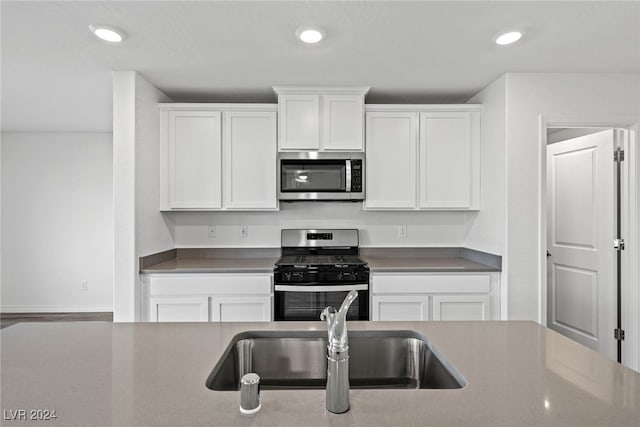 kitchen featuring appliances with stainless steel finishes, sink, and white cabinets