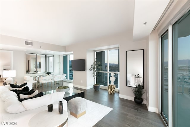 living area featuring dark wood-type flooring, baseboards, and visible vents