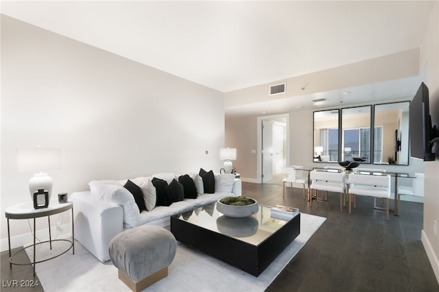 living area featuring visible vents, baseboards, and wood finished floors