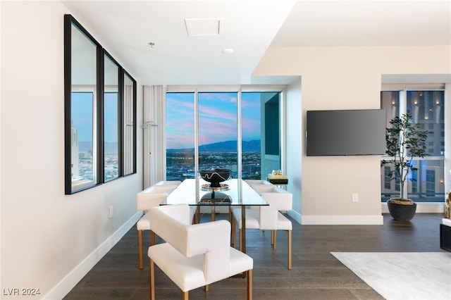 dining room featuring a wall of windows, baseboards, and wood finished floors