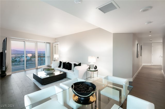 living area featuring visible vents, baseboards, and wood finished floors