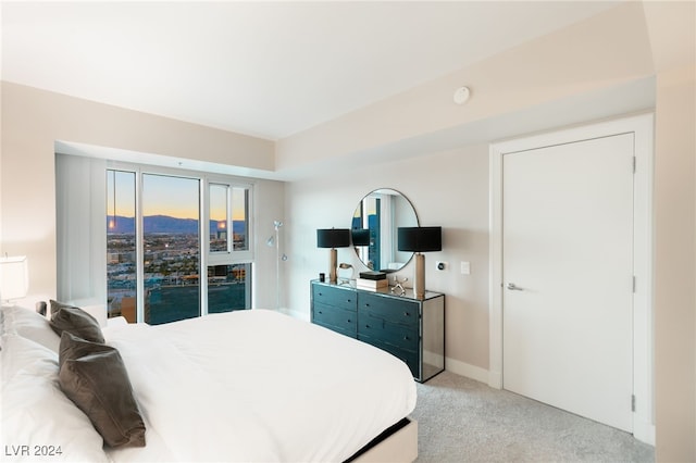 bedroom with light colored carpet and baseboards