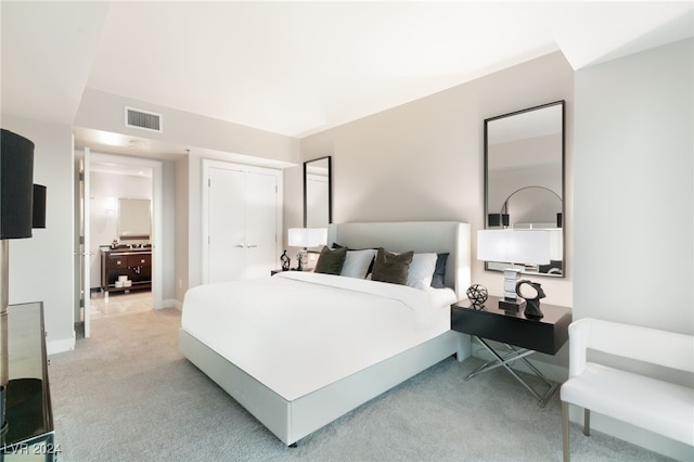 bedroom with light carpet, visible vents, baseboards, and a closet