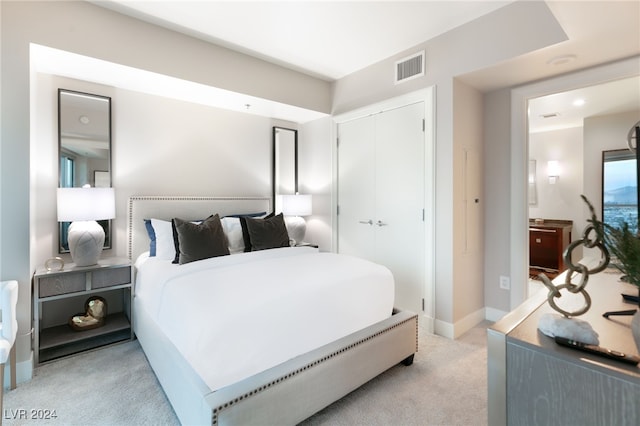 bedroom with light colored carpet, visible vents, a closet, and baseboards