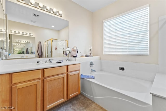 bathroom with tile patterned flooring, vanity, and plus walk in shower