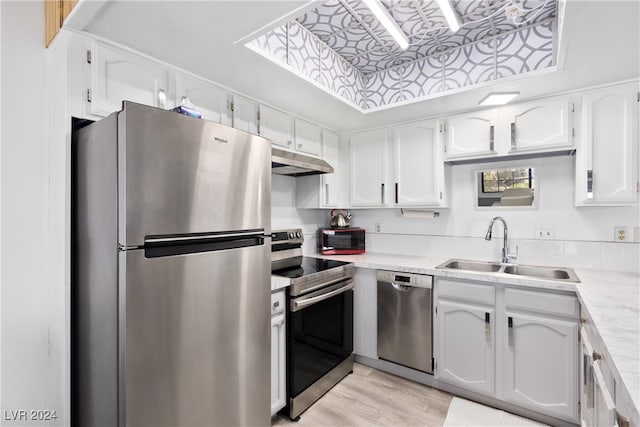 kitchen with stainless steel appliances, white cabinets, and sink