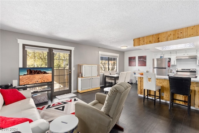 living room featuring a textured ceiling, dark hardwood / wood-style floors, and plenty of natural light