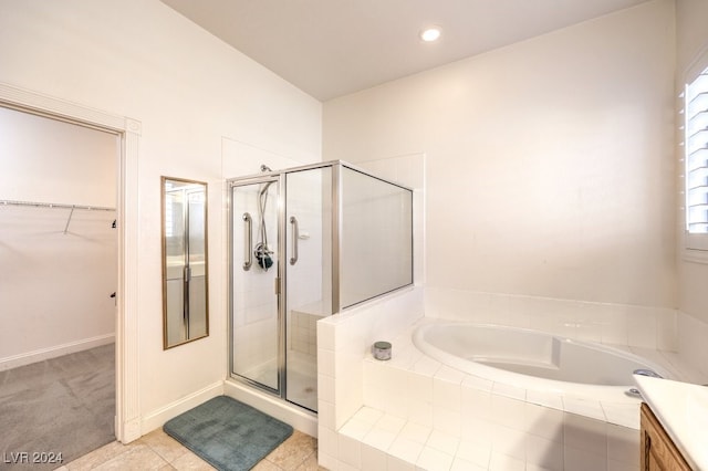 bathroom featuring tile patterned floors, vanity, and shower with separate bathtub