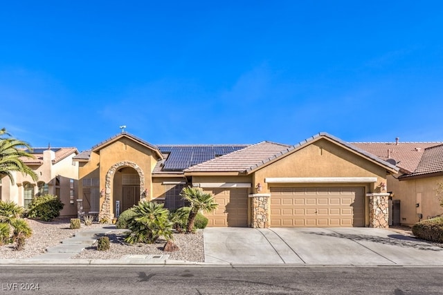 view of front of property featuring solar panels and a garage