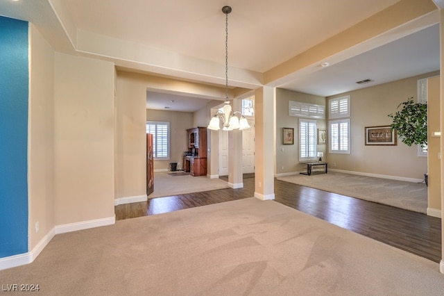 unfurnished dining area featuring hardwood / wood-style floors, plenty of natural light, and a chandelier