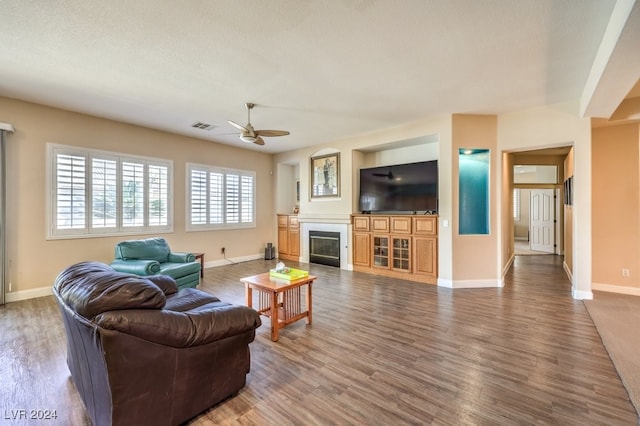 living room with a textured ceiling, hardwood / wood-style flooring, and ceiling fan