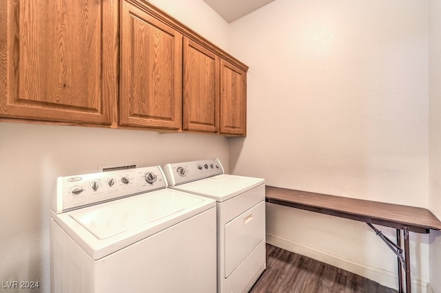 washroom featuring washer and dryer, dark wood-type flooring, and cabinets