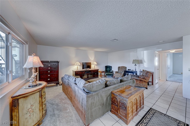 living room with a textured ceiling and light tile patterned floors