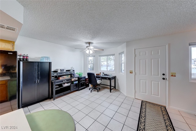 tiled office space featuring ceiling fan and a textured ceiling