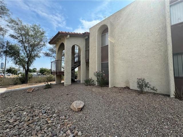 4464 W Desert Inn Rd Unit A, Las Vegas, NV 89102 - view of side of property featuring stucco siding, a tile roof, and stairs