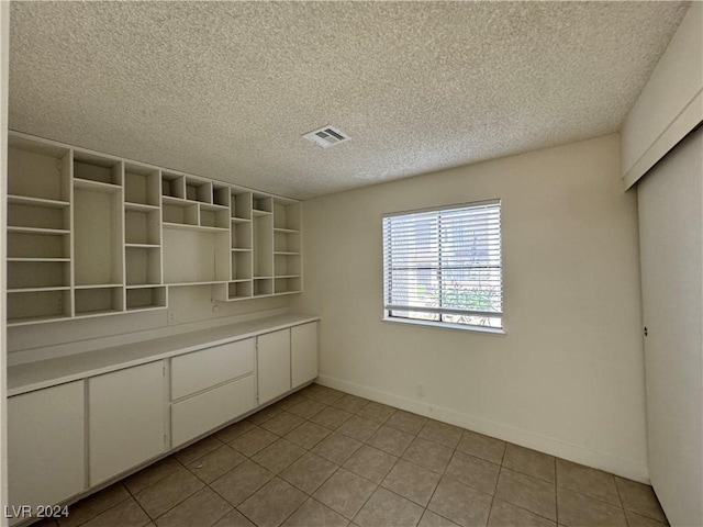 4464 W Desert Inn Rd Unit A, Las Vegas, NV 89102 - unfurnished dining area featuring light tile patterned floors, a textured ceiling, and baseboards