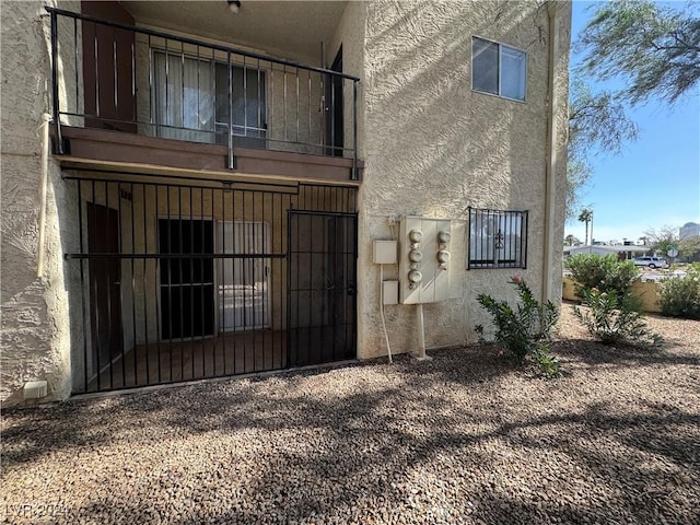 4464 W Desert Inn Rd Unit A, Las Vegas, NV 89102 - back of house featuring a balcony, stucco siding, a gate, and fence