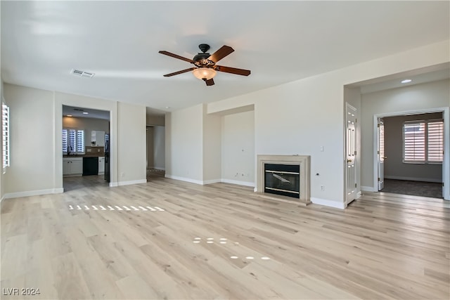 unfurnished living room featuring light hardwood / wood-style floors and ceiling fan