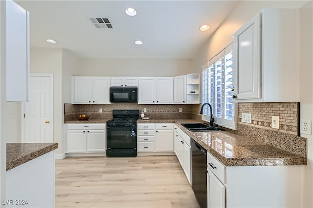 kitchen with black appliances, white cabinetry, decorative backsplash, sink, and light hardwood / wood-style floors