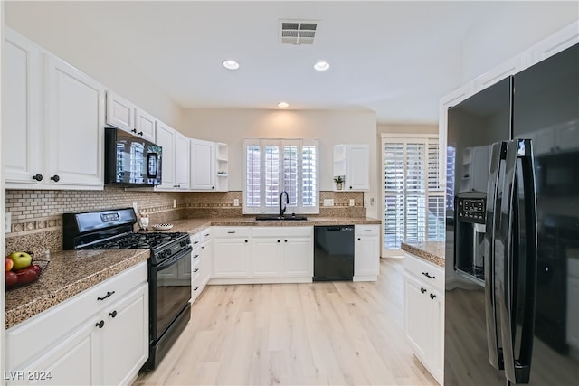 kitchen with white cabinetry, light wood-type flooring, black appliances, and sink