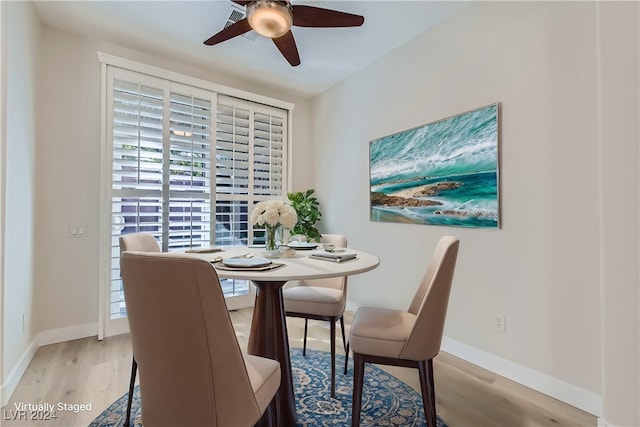 dining room with ceiling fan and light hardwood / wood-style floors