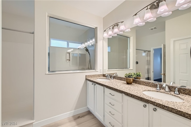 bathroom featuring a shower, vanity, and hardwood / wood-style floors