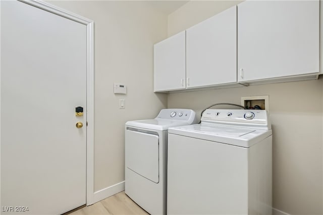 washroom with light wood-type flooring, cabinets, and independent washer and dryer