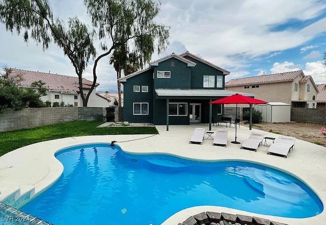 rear view of house with a patio and a fenced in pool