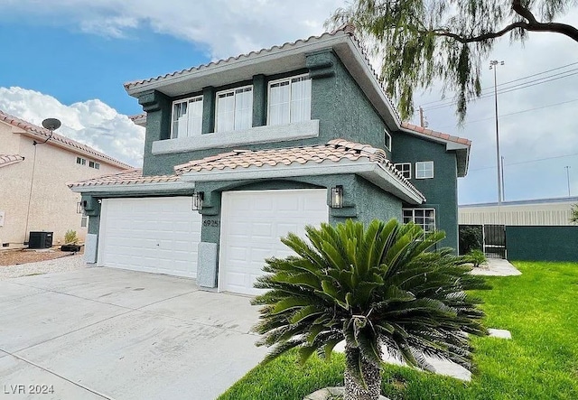 view of front of home with a garage, cooling unit, and a front yard