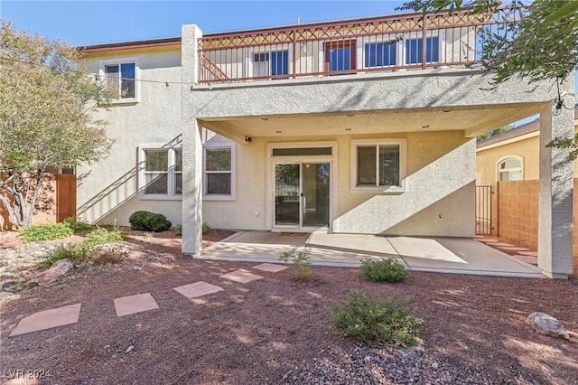 back of house featuring a balcony and a patio