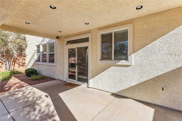 view of exterior entry featuring a patio area