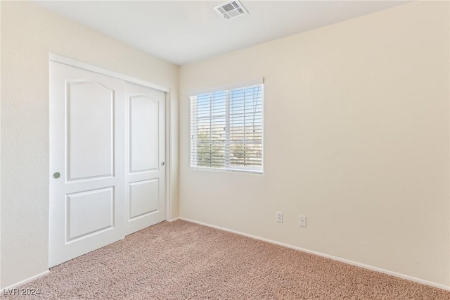 unfurnished bedroom with a closet and carpet floors