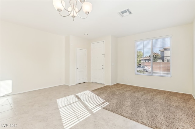 unfurnished room with a chandelier and carpet floors