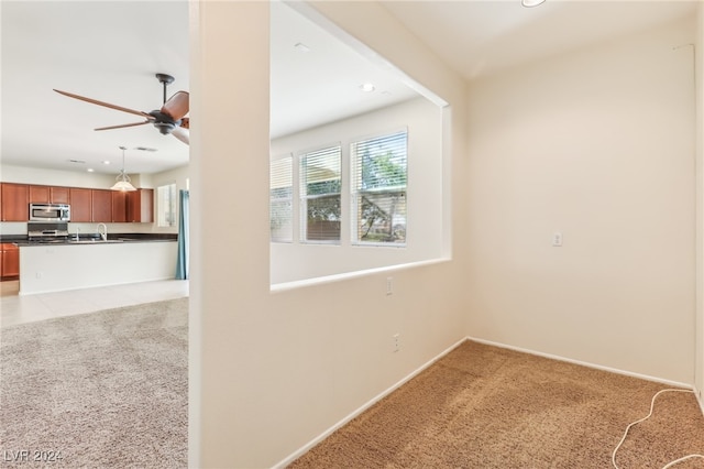 interior space with ceiling fan, carpet floors, and sink