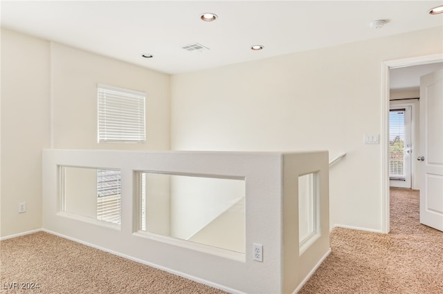 hallway featuring light colored carpet