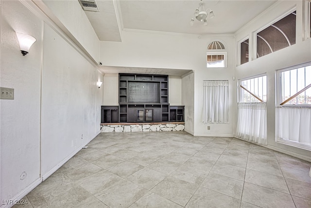 unfurnished living room with a high ceiling, light tile patterned floors, an inviting chandelier, and crown molding