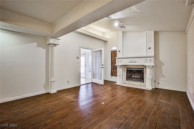 unfurnished living room with ornamental molding, a tiled fireplace, dark wood-type flooring, and a textured ceiling