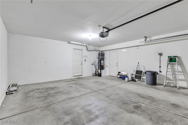 garage featuring a garage door opener and strapped water heater