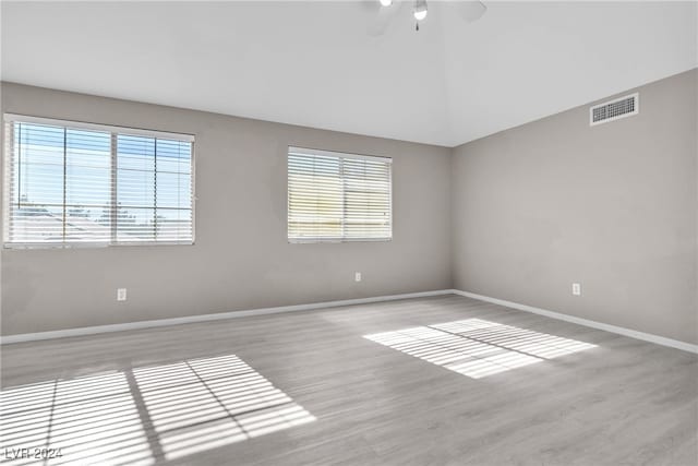 spare room with ceiling fan, a healthy amount of sunlight, and light wood-type flooring