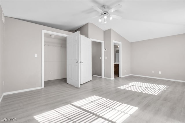 unfurnished bedroom with light hardwood / wood-style floors, ceiling fan, a walk in closet, and a closet