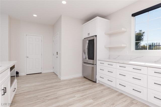 kitchen with recessed lighting, light stone counters, white cabinets, and stainless steel fridge with ice dispenser