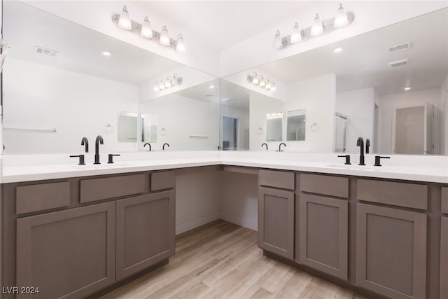 bathroom with walk in shower, vanity, and hardwood / wood-style flooring