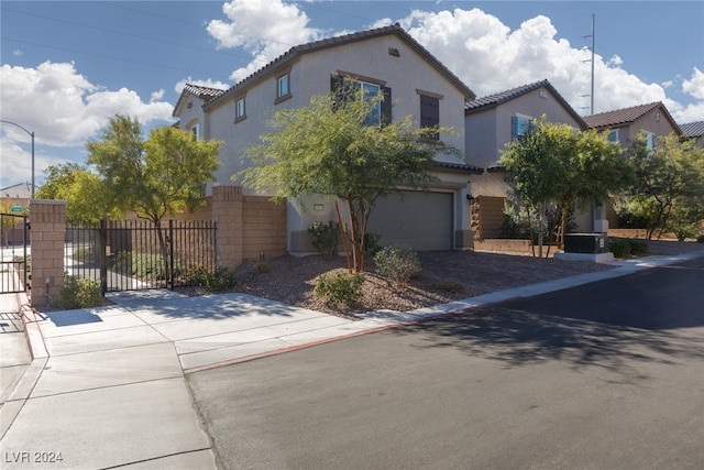 mediterranean / spanish home with a garage, fence, a tiled roof, driveway, and stucco siding