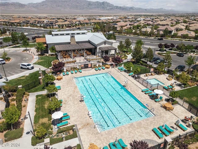 community pool with a mountain view and fence