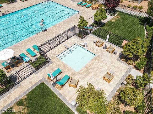 view of swimming pool with a yard and fence