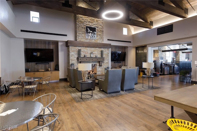 living area featuring hardwood / wood-style flooring, a high ceiling, and beamed ceiling