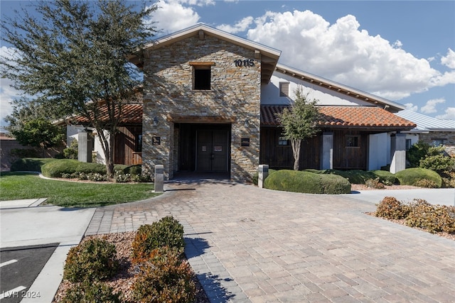 view of front of property featuring stone siding and a front yard