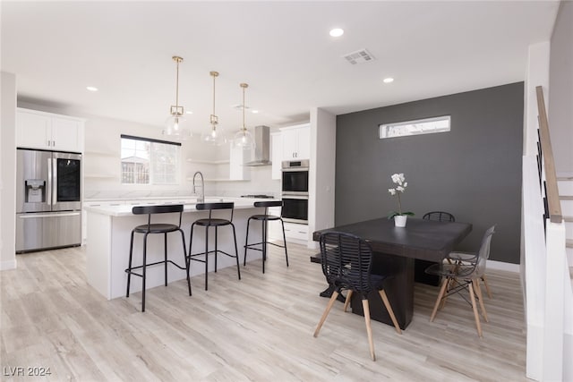 dining area with sink and light wood-type flooring