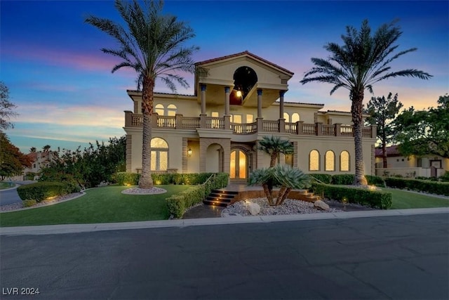 mediterranean / spanish-style house with a lawn and a balcony